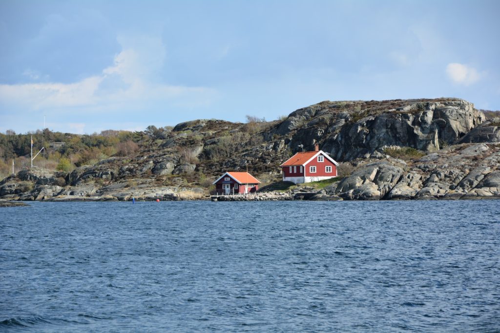 houses on rock formation near body of water during daytime